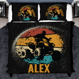 a bed with a black comforter and a motorcycle on it