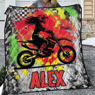 a woman holding up a blanket with a picture of a person on a dirt bike