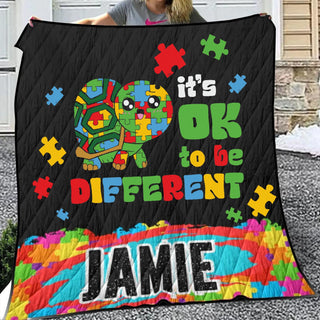 a woman holding up a quilt with a picture of a turtle on it