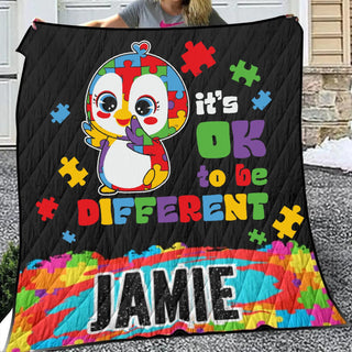 a woman holding a quilt with a picture of a penguin on it