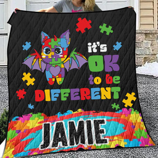 a woman holding a quilt with a picture of a bat on it