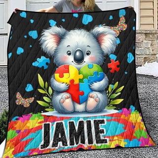 a woman holding a quilt with a picture of a koala holding a puzzle