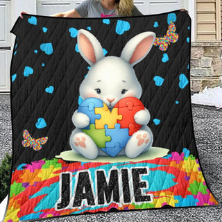 a woman holding up a quilt with a picture of a bunny holding a puzzle