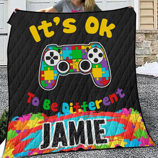 a woman holding a quilt with a video game controller on it