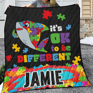 a woman is holding a quilt with a shark on it