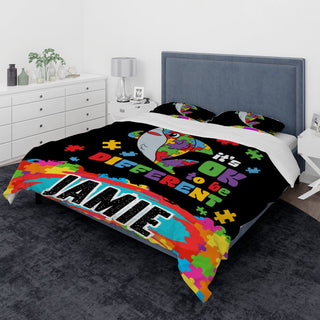 a bed covered in a black comforter with a name on it