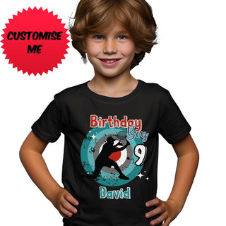 a young boy wearing a birthday shirt with a penguin on it