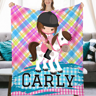 a girl is holding a blanket with a horse on it