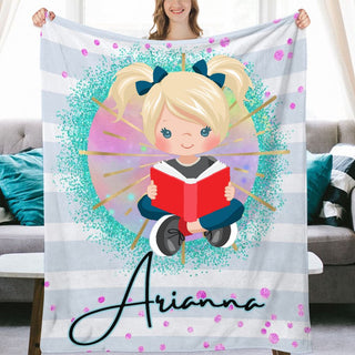 a woman holding a personalized blanket with a picture of a girl reading a book