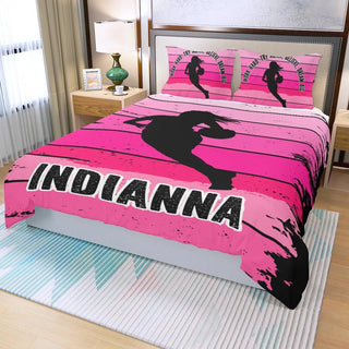 a bed with a pink bed cover with a picture of a girl on it