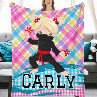 a girl holding up a personalized blanket