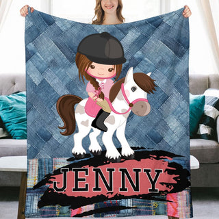 a woman holding a blanket with a picture of a girl riding a horse