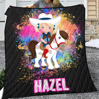 a woman holding a blanket with a picture of a girl on a horse