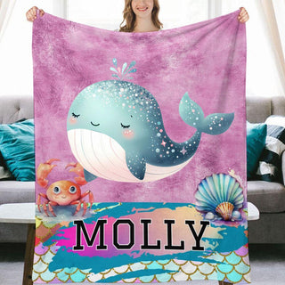 a woman holding a blanket with a whale on it