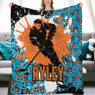 a woman holding up a blue and orange blanket