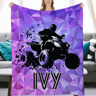 a woman holding a purple blanket with a picture of a monster truck