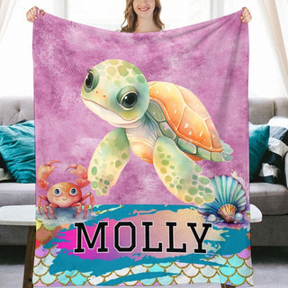 a woman holding a blanket with a picture of a turtle on it