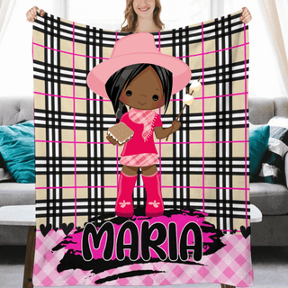 a girl in a pink outfit holding up a personalized blanket