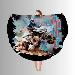 a woman holding up a large blanket with a picture of a person riding a quad