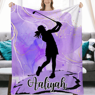 a woman holding a purple blanket with a picture of a girl playing golf