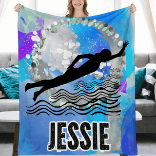 a woman is holding up a towel with a picture of a swimmer