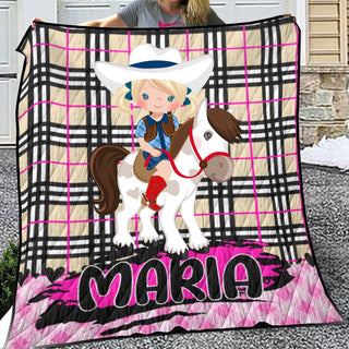 a woman holding a blanket with a picture of a girl riding a horse