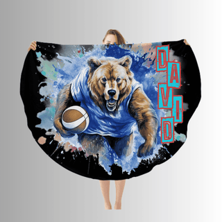 a woman is holding a large blanket with a picture of a bear holding a football