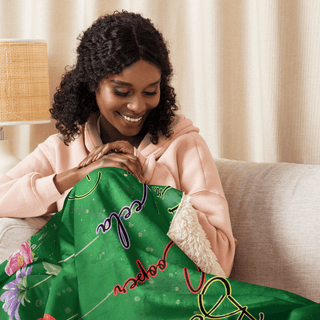 a woman sitting on a couch holding a green blanket