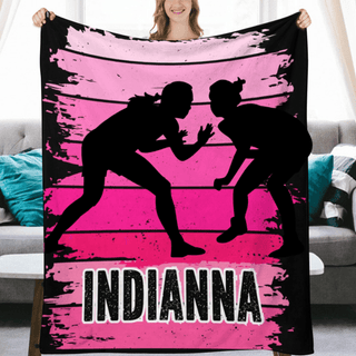 a woman holding up a pink and black blanket