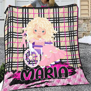 a woman holding a quilt with a picture of a doll on it