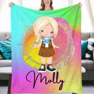 a girl holding a personalized blanket in front of a couch