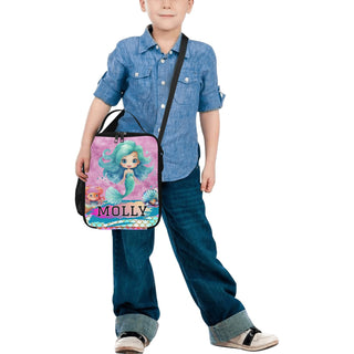 a little boy holding a bag with a picture of a mermaid on it