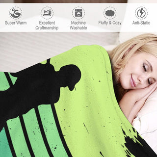 a woman laying in bed under a green and black blanket