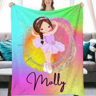 a girl holding a colorful blanket with a picture of a ballerina