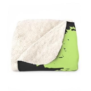 a green and black blanket on a white background