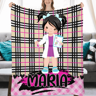 a girl holding a personalized blanket in front of a couch