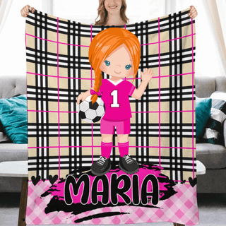 a girl holding up a personalized soccer blanket