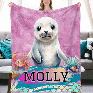 a woman holding a blanket with a picture of a seal on it