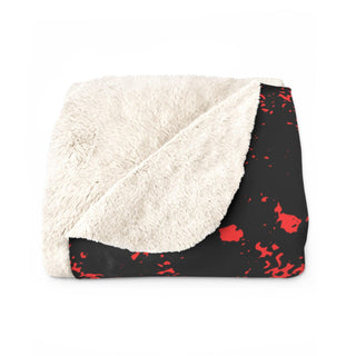 a black and white blanket with red paint splatters