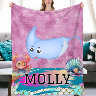 a woman holding a blanket with a picture of a dolphin on it