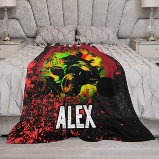 a bed covered in a black and red blanket