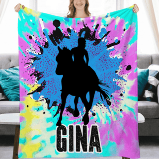 a woman holding a colorful blanket with a picture of a man riding a horse