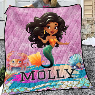 a woman holding a blanket with a picture of a mermaid on it