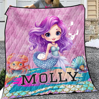 a girl holding a blanket with a picture of a mermaid on it