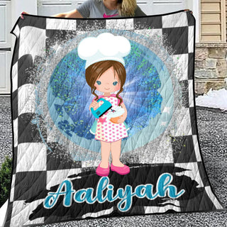 a woman holding a quilt with a picture of a girl in a chef's