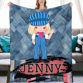 a woman holding up a blanket with a picture of a girl in overalls