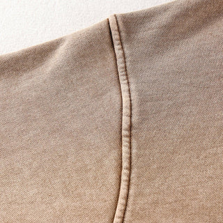 a close up of a person wearing a tan shirt