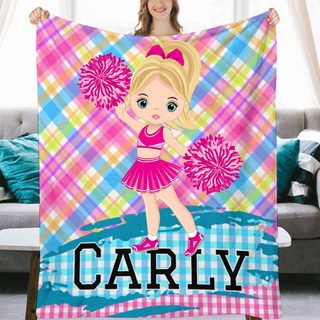 a girl holding a blanket with a cheerleader on it