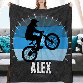 a woman holding a blanket with a picture of a man on a bike