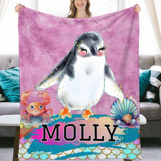 a woman holding a blanket with a penguin on it